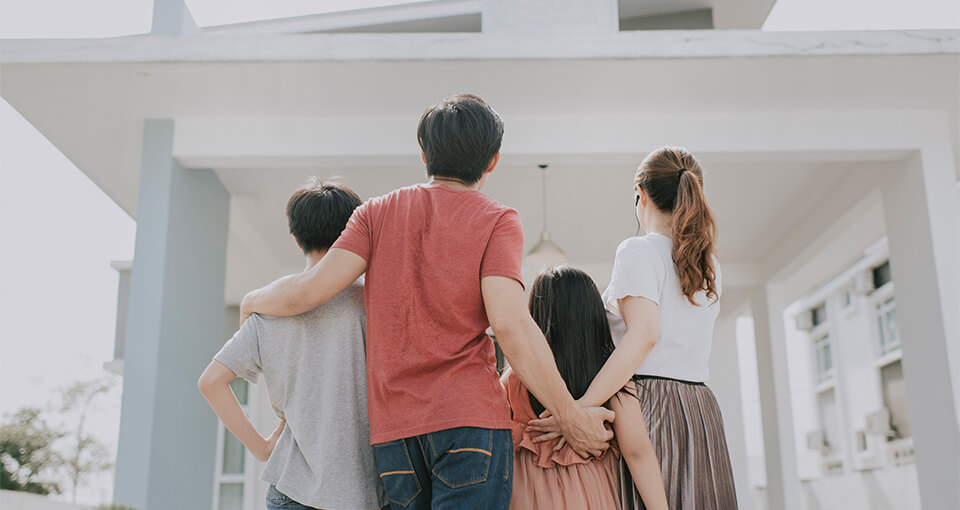 family in front of their new home