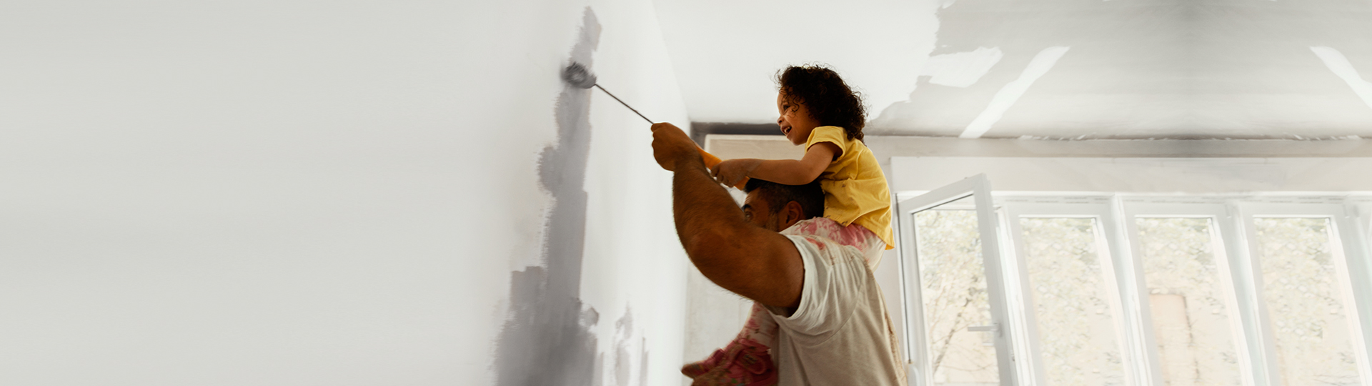Father and daughter painting wall